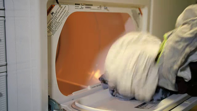 男人把衣服放进烘干机