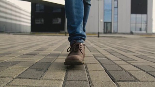 穿着鞋的男人的脚凑在一起向前走着