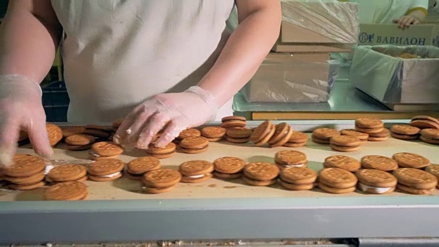 面包房工人在食品工厂操作饼干传送器。4 k。