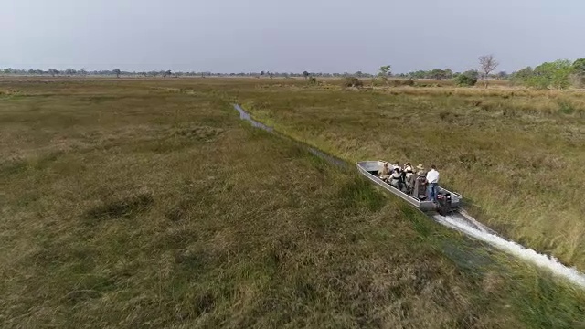 鸟瞰图，一艘游船正在它的许多渠道之一的奥卡万戈三角洲，波斯特瓦纳