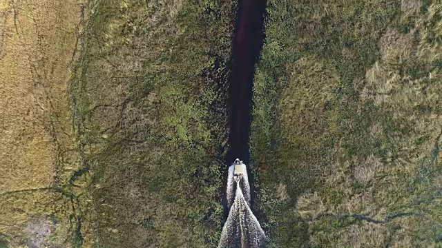 在奥卡万戈三角洲众多弯曲的水道中，一艘游船在高空拍摄的画面被放大了