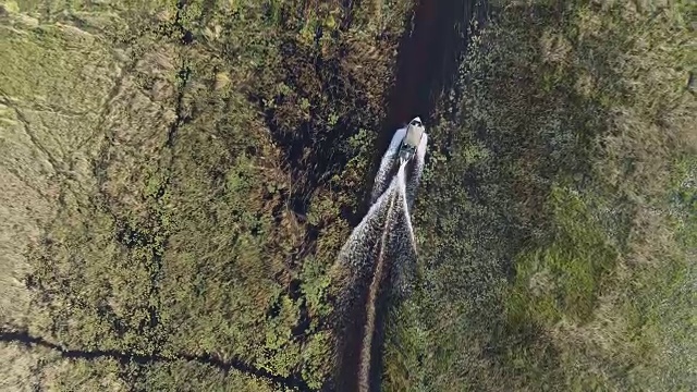 在奥卡万戈三角洲众多弯曲的水道中，一艘游船在高空拍摄的画面被放大了