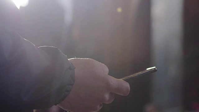 詳情圖-一個男人使用移動智能手機的特寫和陽光與透鏡光暈效果。3840,x2160