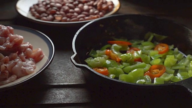 鸡块，豆子。青椒和辣椒在煎锅里。视频