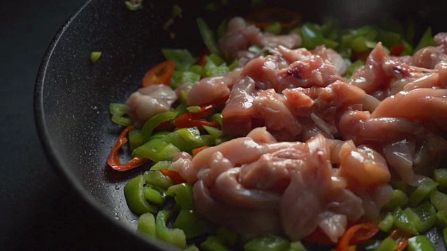 用辣椒和鸡块煎锅特写。视频
