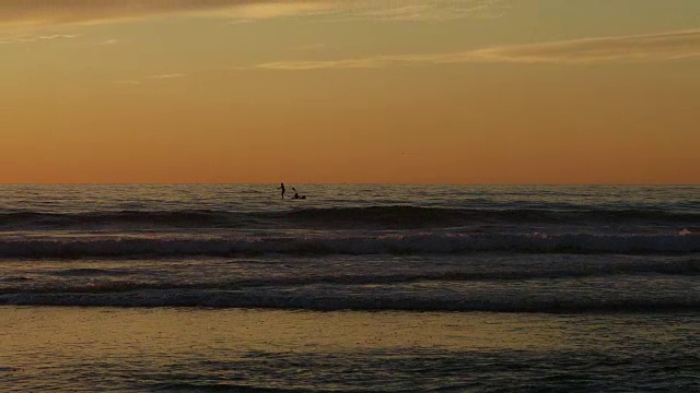 玩，痛苦，皮划艇和划桨在海上与日落的背景，在特里松树海滩，圣地亚哥，CA 100%慢动作