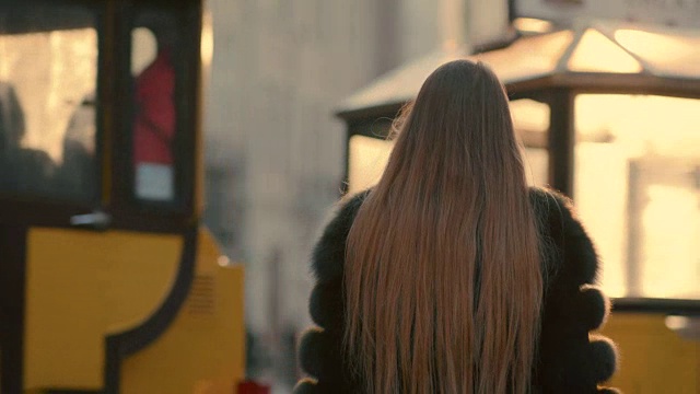 一位迷人的年轻女士正冲向市中心，她对着镜头微笑