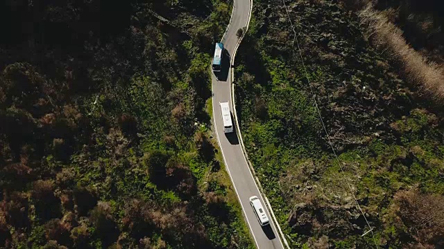 狭窄山路上车辆的鸟瞰图。旅游巴士在路边停车，让迎面而来的汽车通过。安全。4 k