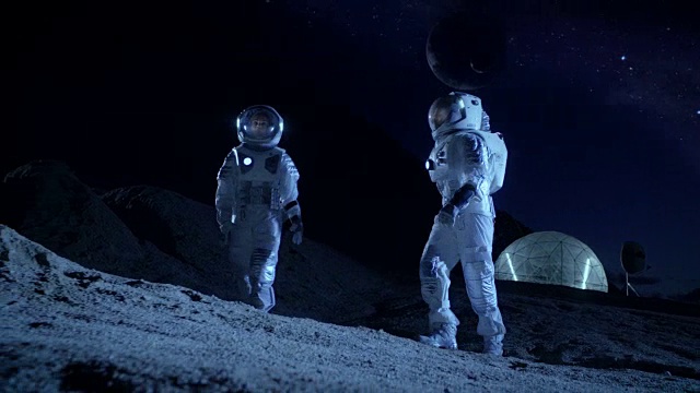 詳情圖-兩名宇航員穿著宇航服探索新發(fā)現(xiàn)的行星。在具有可居住圓頂?shù)谋尘翱臻g基地中，可以看到天空中的外行星。太空殖民的未來概念。