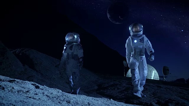 詳情圖-兩名宇航員穿著宇航服探索新發(fā)現(xiàn)的行星。在具有可居住圓頂?shù)谋尘翱臻g基地中，可以看到天空中的外行星。太空殖民的未來概念。