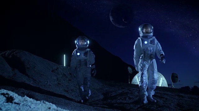 詳情圖-兩名宇航員穿著宇航服探索新發(fā)現(xiàn)的行星。在具有可居住圓頂?shù)谋尘翱臻g基地中，可以看到天空中的外行星。太空殖民的未來概念。