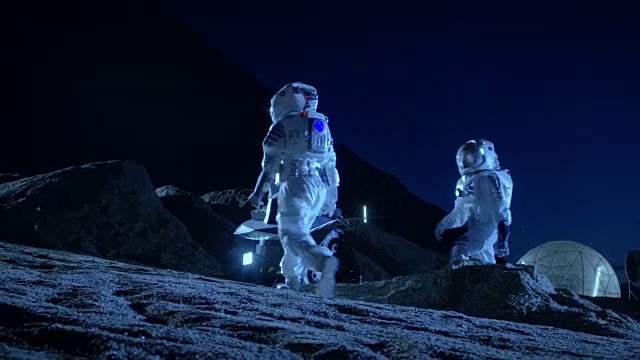 詳情圖-兩名宇航員穿著宇航服在外星球上為表面探索任務準備太空車。關于太空殖民的未來概念。