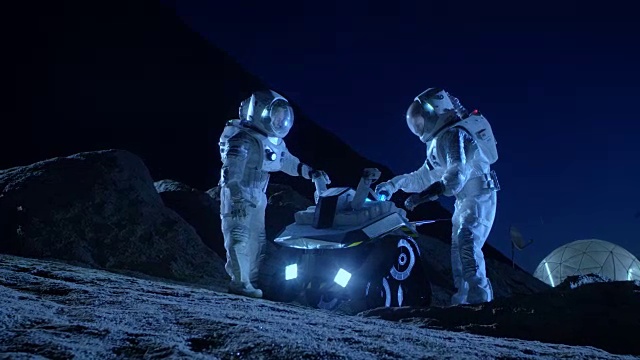 詳情圖-兩名宇航員穿著宇航服在外星球上為表面探索任務準備太空車。關于太空殖民的未來概念。