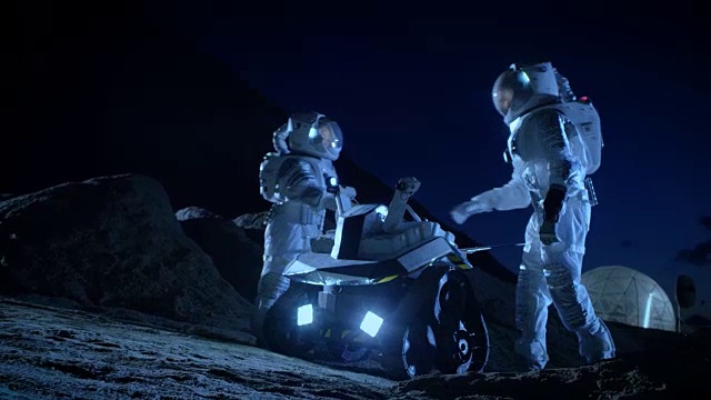 詳情圖-兩名宇航員穿著宇航服在外星球上為表面探索任務(wù)準(zhǔn)備太空車。關(guān)于太空殖民的未來(lái)概念。