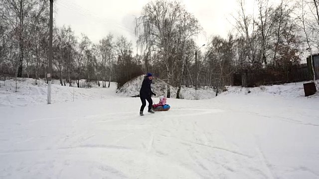 妈妈宝宝在雪橇上滚动