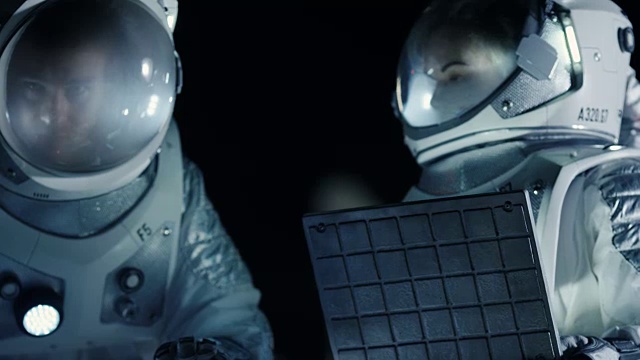 詳情圖-兩名宇航員穿著宇航服在外星球上為火星表面探險(xiǎn)準(zhǔn)備探測(cè)器，使用筆記本電腦。太空旅行和太陽(yáng)系殖民概念。