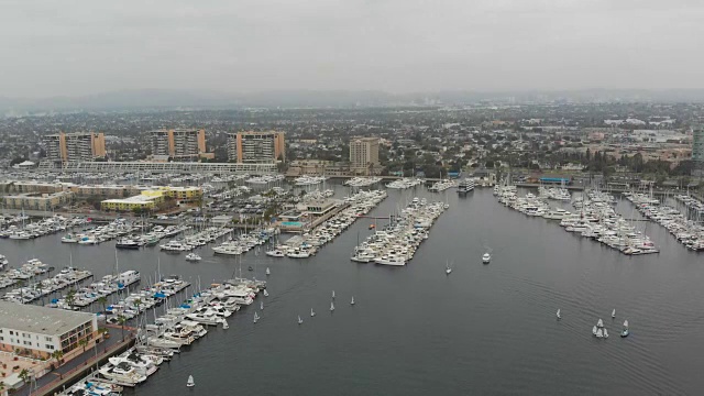 无人机拍摄在Marina Del Rey码头，加州与海洋，码头，船，游艇，建筑，酒店，帆船和多云的天空