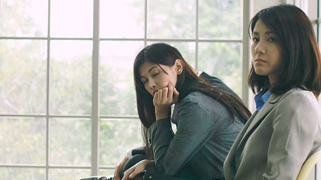 一群亚洲人紧张地等待着面试。