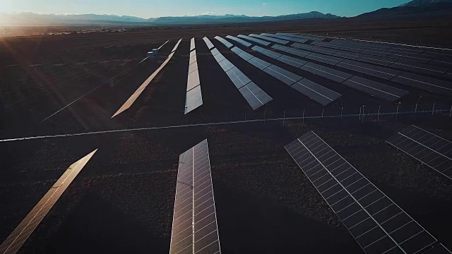 空中沙漠观大型工业太阳能农场生产集中太阳能。绕山而行，夕阳西下。