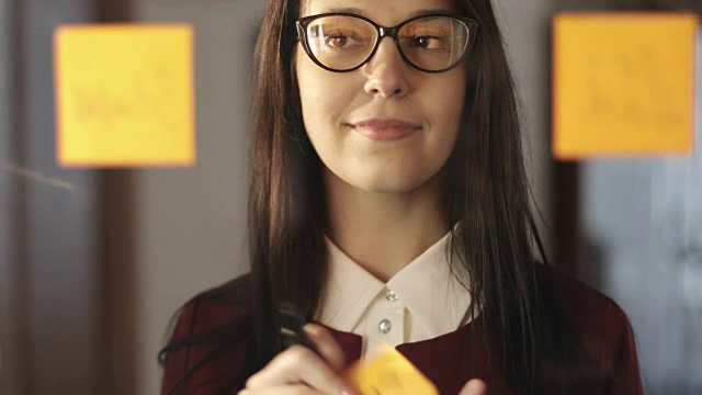 詳情圖-漂亮的女商人戴著眼鏡在辦公室的玻璃貼紙和膠水上寫信息。