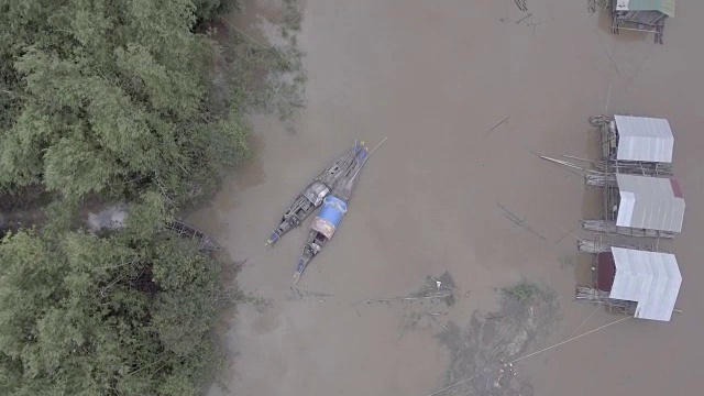 空中垂直拍摄，俯瞰被暴雨淹没的河岸上漂浮的房屋