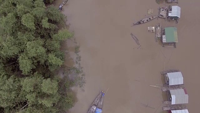 空中垂直拍摄，俯瞰被暴雨淹没的河岸上漂浮的房屋