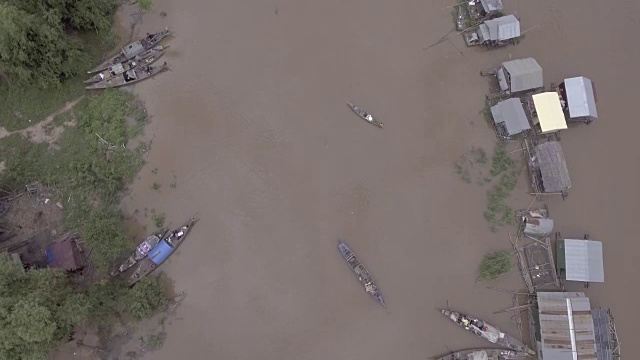 空中垂直拍摄，俯瞰被暴雨淹没的河岸上漂浮的房屋