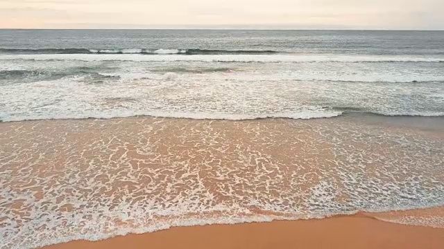 海浪越过沙滩背景
