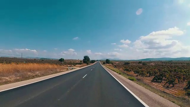 在西班牙，骑摩托车的人在风景优美的沙漠和空旷的道路上。第一个人的观点
