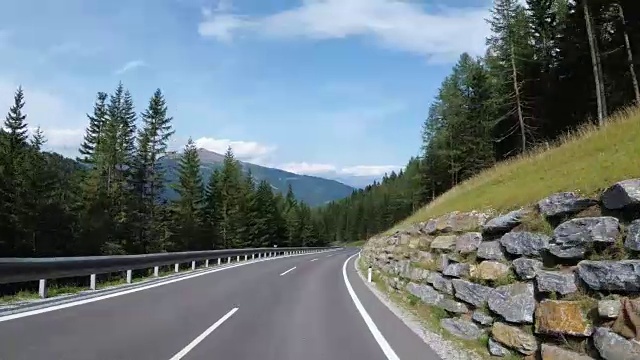 奥地利，骑摩托车的人在风景优美的山路上。第一人称视角