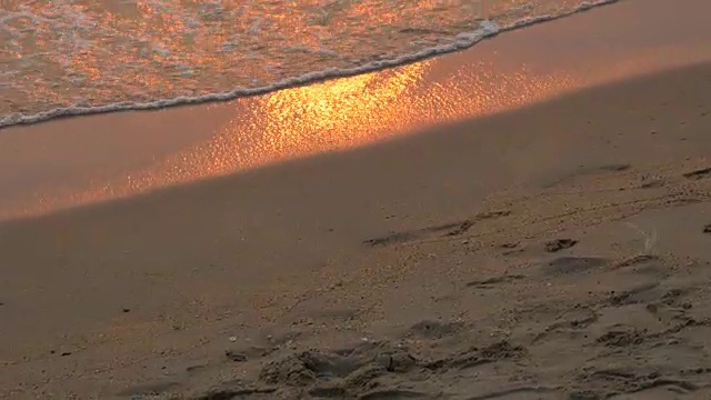 日落时的海岸，落日的红光在上面闪烁