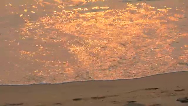 日落时的海岸，落日的红光在上面闪烁