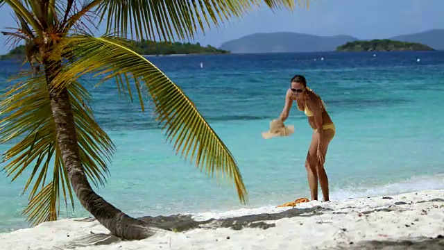 在加勒比海的热带海滩上，一个女人穿着纱笼走着