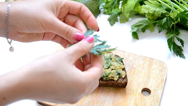 详情图-用刀抹在牛油果面包上。生的和健康的素食食品