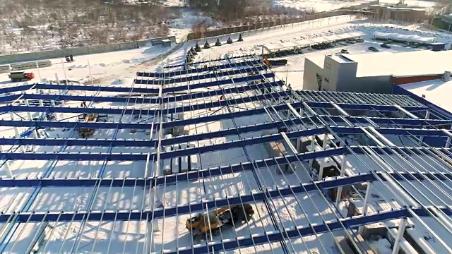 建设现代化工厂或厂房，工业区在冬季，从空中一览无余。现代化的厂房在白雪皑皑的田野上，新建了一座钢结构的商业建筑