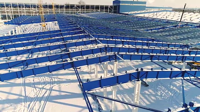 建设现代化工厂或厂房，工业区在冬季，从空中一览无余。现代化的厂房在白雪皑皑的田野上，新建了一座钢结构的商业建筑