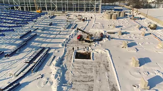建设现代化工厂或厂房，工业区在冬季，从空中一览无余。现代化的厂房在白雪皑皑的田野上，新建了一座钢结构的商业建筑
