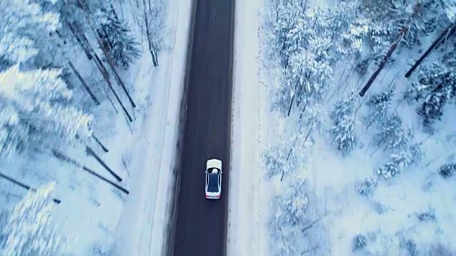 汽车在冬天的路上行驶。冬天的路上，树木和灌木丛被雪覆盖着。