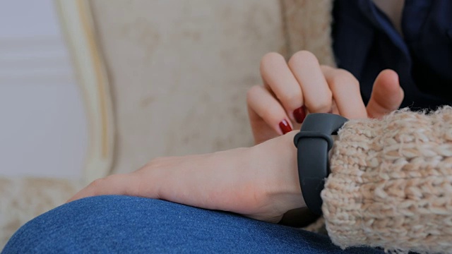 详情图-年轻女子使用可穿戴智能健身追踪器