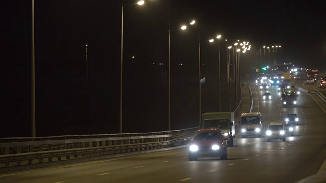 夜间公路交通车辆。傍晚，汽车在桥上行驶。黑暗中的高速公路。加里宁格勒- 2017年11月俄罗斯