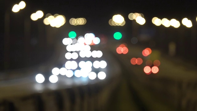 夜间公路交通车辆。泛在城市模糊背景。夜景交通的移动散景圈。傍晚，汽车在桥上行驶。黑暗中的高速公路。