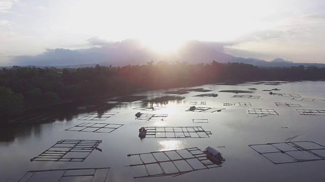 太阳从建在湖中央的竹制建筑上升起。无人机航拍，剪影