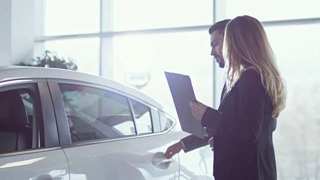 女售货员向富客户端展示新车