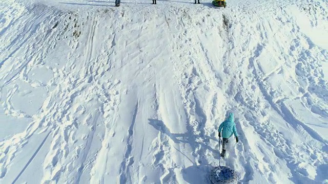 孩子们在玩，用充气雪橇从山上滚下来