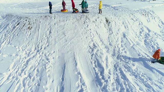 孩子们在玩，用充气雪橇从山上滚下来