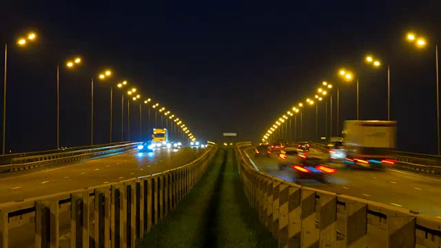 公路交通车辆在夜间时间流逝。汽车行驶在道路上的桥晚上延时。4 k UHD