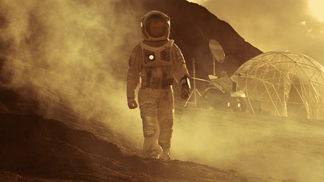 詳情圖-穿著太空服的宇航員行走在紅色星球/火星上。在背景中，他的基地停放著Rover，熾熱的陽(yáng)光照耀著。