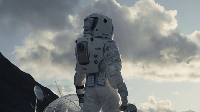 詳情圖-緊接著拍攝的宇航員在冰凍的外星星球上環(huán)顧四周。背景:他的基地/研究站。科技的進(jìn)步帶來了太空探索和殖民。