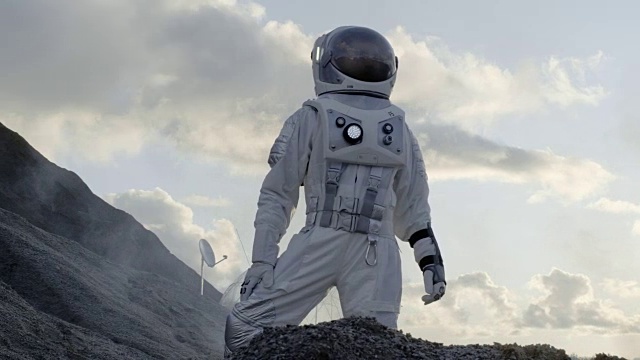 詳情圖-宇航員站在寒冷的外星山上環(huán)顧四周。背景:他的基地/研究站?？萍嫉倪M(jìn)步帶來了太空探索和殖民。