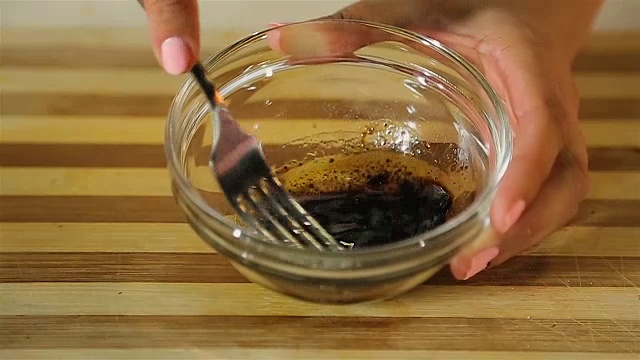 烹饪爱好者用叉子混合自制沙拉酱在碗里，饮食文化